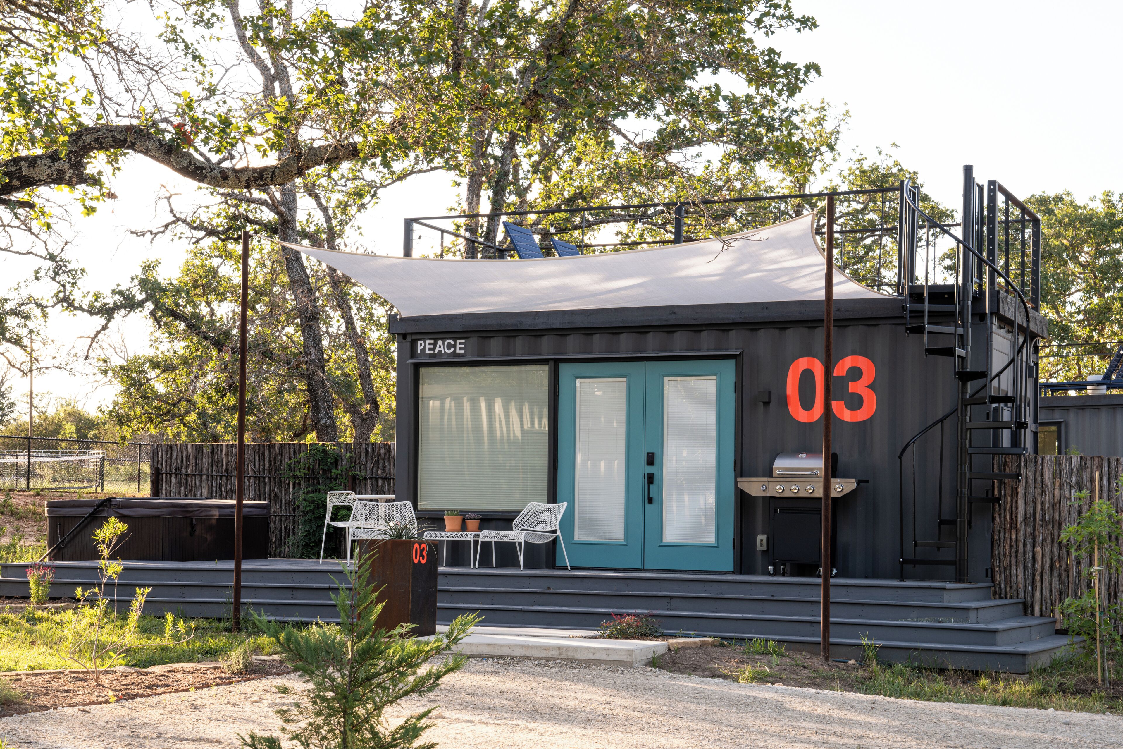 A modern building with a blue door labeled "PEACE" and the number "03" on the side.