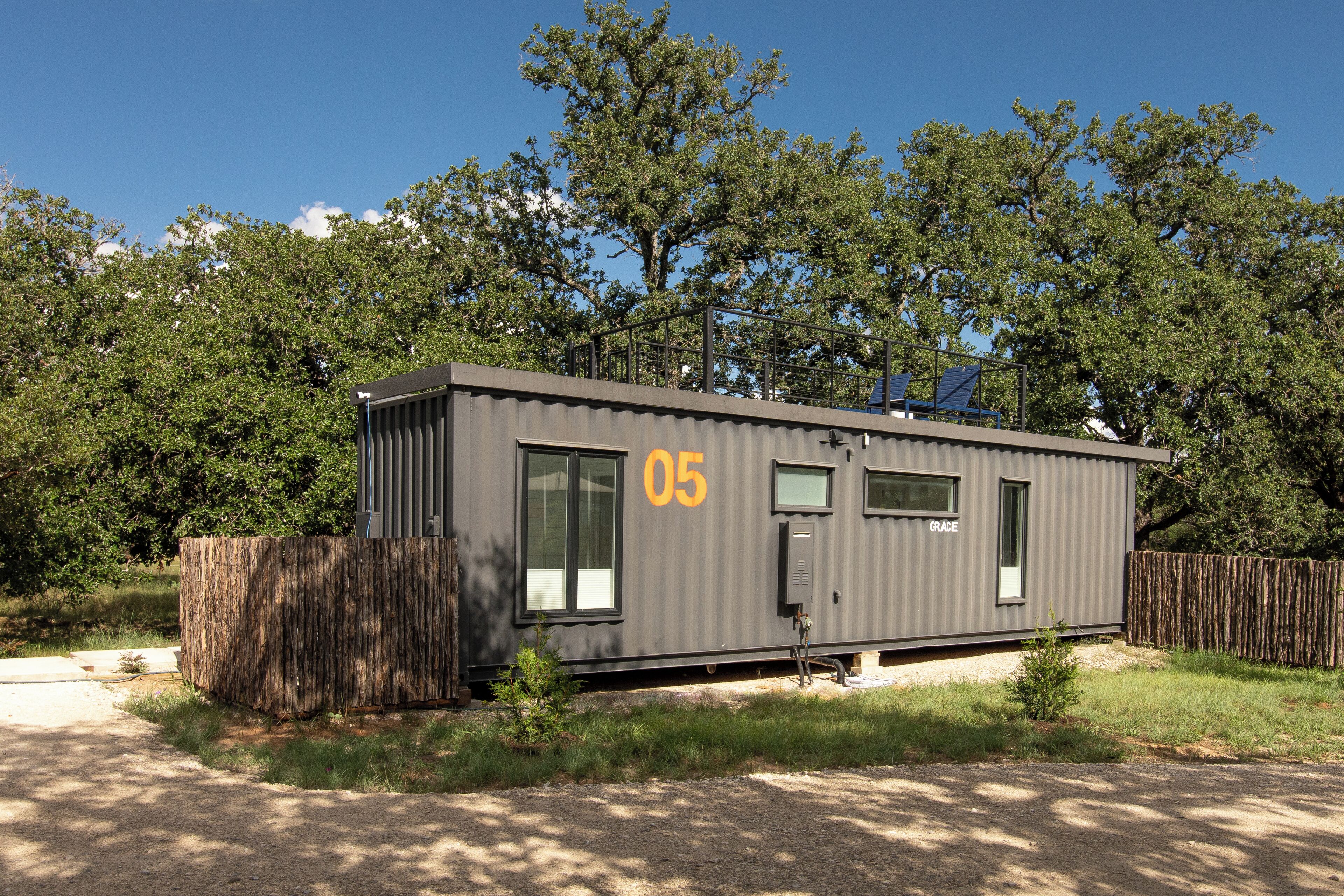 A compact, single-story cabin with a grey exterior, number 05, and a small porch area.