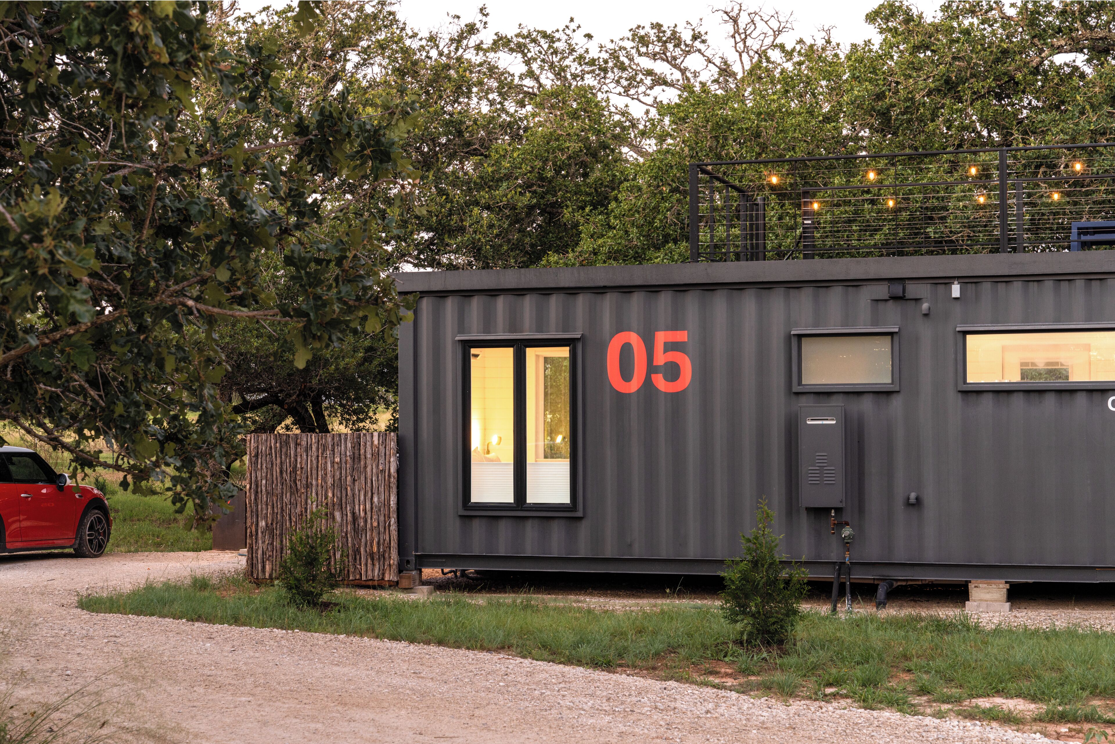 A modern, compact building with a large window and a door, marked with the number 05.
