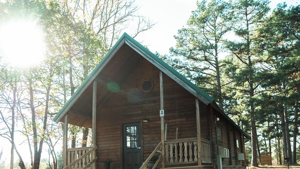 A wooden cabin with a stone foundation, a front porch, and a staircase leading to the entrance. - 2 Lakeside : Charming 2-bedroom cabin with AC, WiFi in welcoming Solgohachia (Solgohachia)