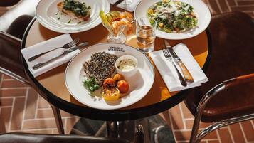 A table set with plates of food, glasses of water, and cutlery.
