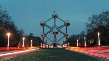 A large, symmetrical structure with multiple spherical elements, surrounded by a well-lit pathway and trees.