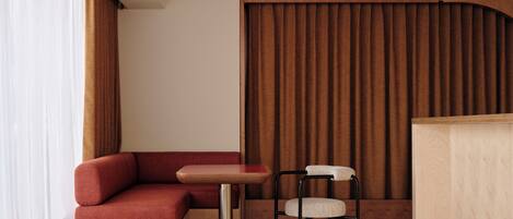 Una habitación moderna con un banco de madera, una mesita y una silla.