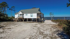 A beachfront house with a balcony and a staircase leading to the main floor. - Bayside 3 bedroom Bungalow (Gulf Shores)
