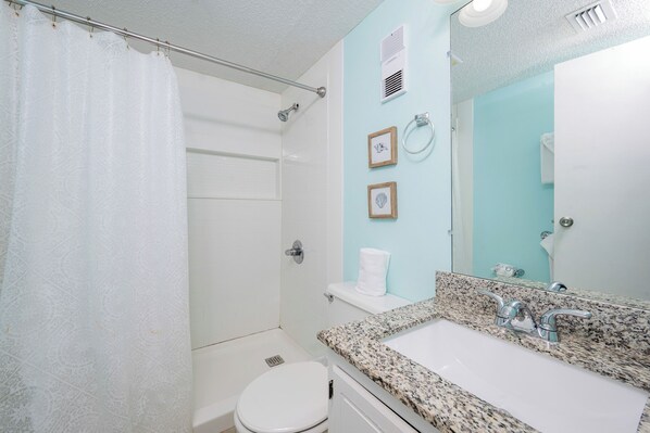 A bathroom with a shower, toilet, sink, and a mirror. - The Royal Gulf Beach & Racquet Club 5210 (Gulf Shores)