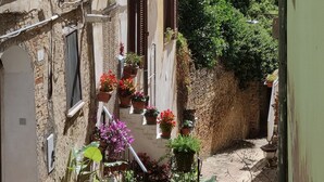 A narrow alleyway with buildings on either side, potted plants, and a view of distant mountains. - Newly renovated apartment,  ideal for relaxing, nature lovers and walkers  

 (Abruzzo)