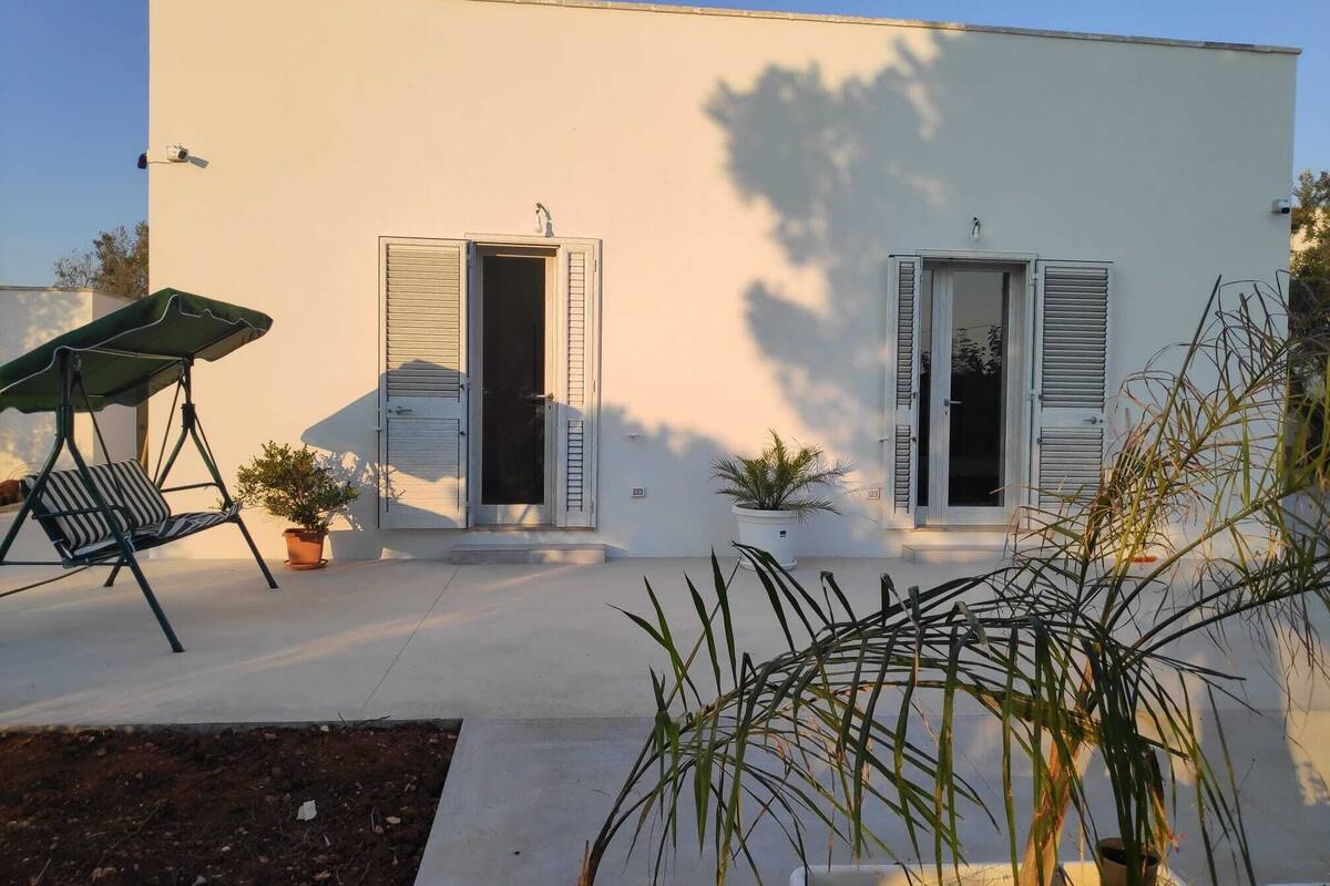 Un bâtiment moderne doté de deux portes et d’un fauteuil suspendu avec un auvent.