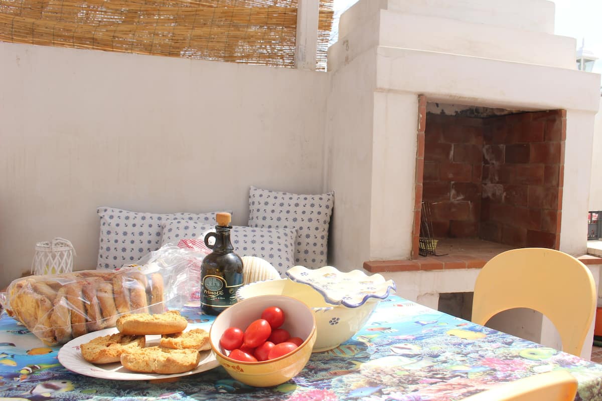 Une table avec des aliments, une bouteille et un bol de tomates.