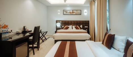 A hotel room with a bed, desk, chair, and a ceiling fan.