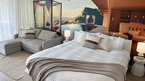 A hotel room with a bed, a sofa, a view of a mountainous landscape, and a pool. - Bay View Motel - Sunrise (Lorne)