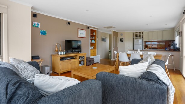 A modern living room with a sofa set, a television, and a wooden coffee table. - Sound Of The Sea (Apollo Bay)