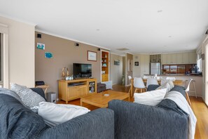 A modern living room with a sofa set, a television, and a wooden coffee table.