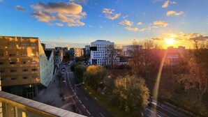 A cityscape with modern buildings, a clear sky, and a sunset. - Luxury apartment (Lille)