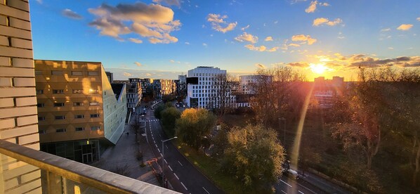A cityscape with modern buildings, a clear sky, and a sunset.