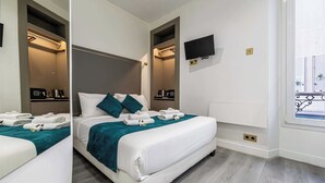 Een moderne hotelkamer met een groot bed, een aan de muur bevestigde televisie en een raam met uitzicht.