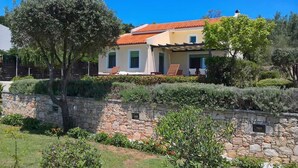 A two-story house with a stone wall and a red-tiled roof. - Villa Nerissa, Villa Nerissa (Alonnisos)