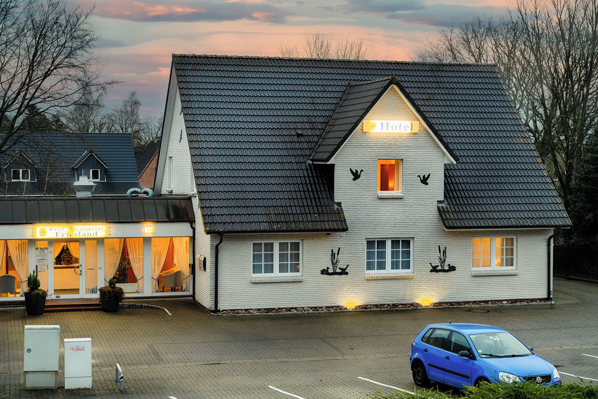 Un hotel de dos pisos con techo inclinado y un letrero que dice 'Home'.