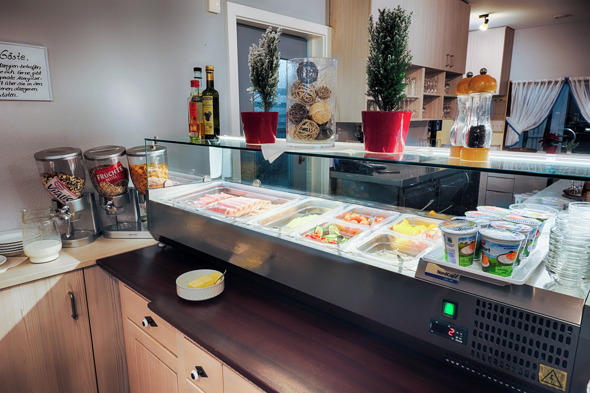 A buffet area with various food options, condiment dispensers, and a coffee machine.