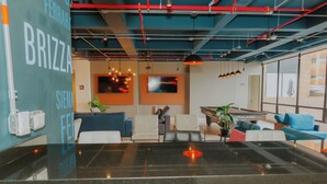 Un interior moderno con un mostrador de recepción, una zona de estar y un ventanal con vistas.