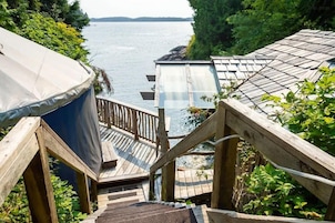 Una escalera de madera que lleva a una terraza con vistas a un lago.