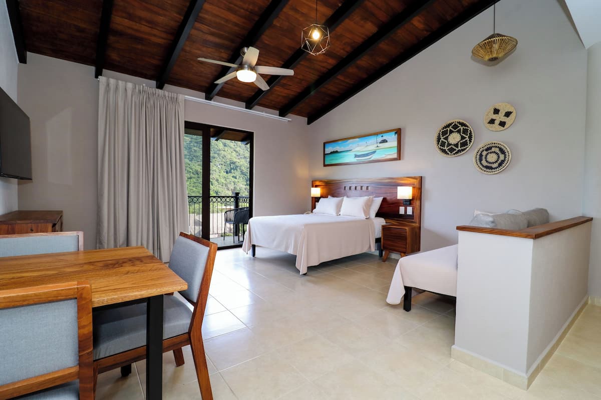 A bedroom with a bed, bedside tables, a desk, and a chair.