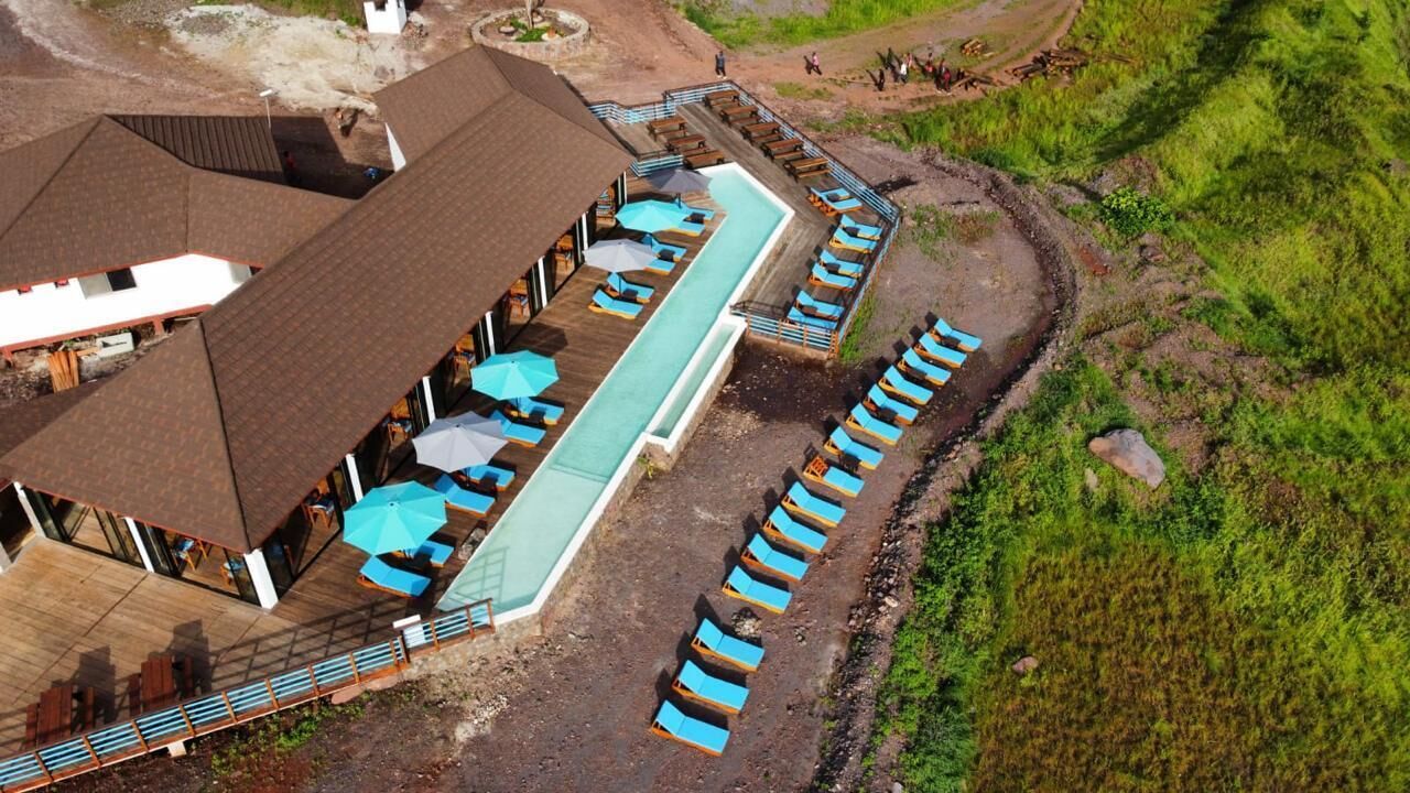 A resort with a pool, lounge chairs, and a wooden deck.