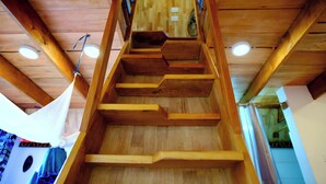 Een houten trap met een sober ontwerp, leidend naar een hoger gelegen verdieping.