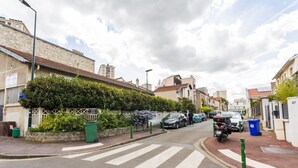A residential street with houses, parked cars, and a clear pedestrian crossing.
