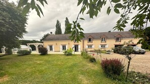 A two-story house with a covered patio area and a well-maintained lawn. - L'Hydromel, estate with swimming pool 1h30 from Paris (Auvilliers-en-Gâtinais)
