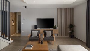A modern living room with a flat-screen TV, two grey sofas, a wooden coffee table, and a grey rug. - Villa Adria in Valbandon (Valbandon)