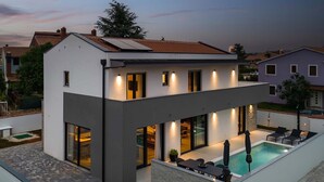 A modern two-story house with a swimming pool, large windows, and outdoor seating. - Villa Adria in Valbandon (Valbandon)