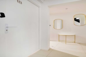 Experience a serene retreat with a white door, console table, and wall-mounted mirrors.