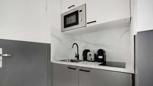 A compact kitchen with a built-in microwave, a sink, and a toaster. - Cosy Studio for 2P with A/C - Near Montmartre (Paris)