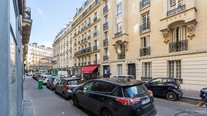A street view with parked cars and buildings with balconies. - Cosy Studio - 4P - Palais des Congres (Paris)