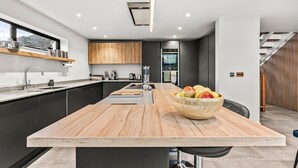 A modern kitchen with a central island, built-in appliances, and a view of the outdoors.