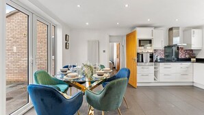 A modern kitchen with white cabinets, a built-in oven, and a black countertop. - Boutique Cambridgeshire Gem (Cambridge)