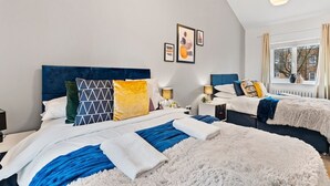 A modern bedroom with a large bed, two bedside tables, and a window with curtains. - Boutique Cambridgeshire Gem (Cambridge)