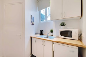 Microondas, placa de cocina, cafetera o tetera y utensilios de cocina