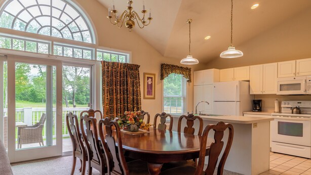 A kitchen with a dining area, large windows, and a view of the outdoors. - Charming townhome in brilliant Bethel, close to Sunday River. (Bethel)