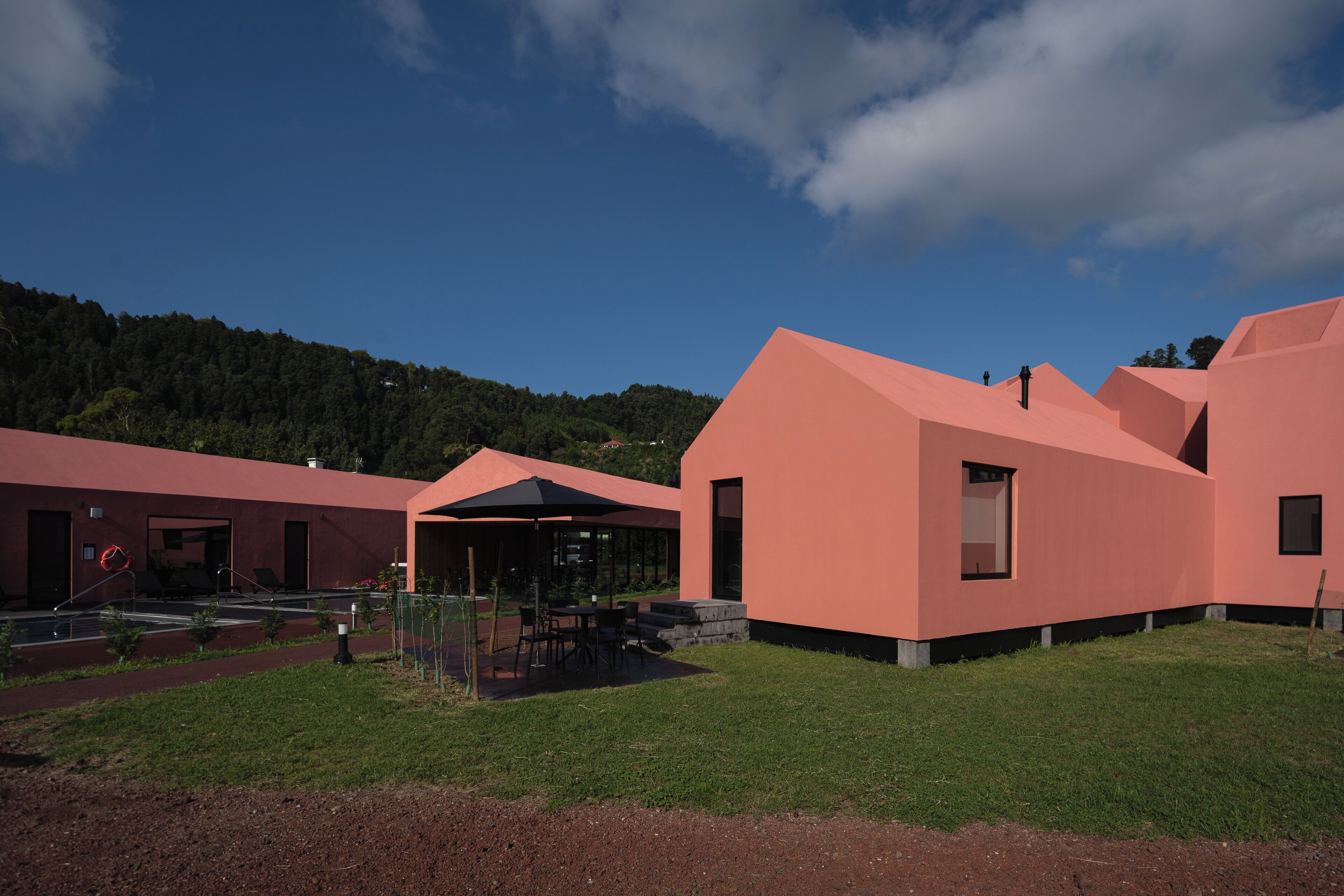 Un edificio moderno con tetto piano e una zona salotto esterna coperta.