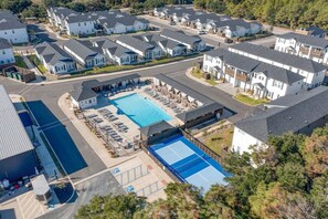 A residential area with multiple houses, a swimming pool, and a parking lot.
