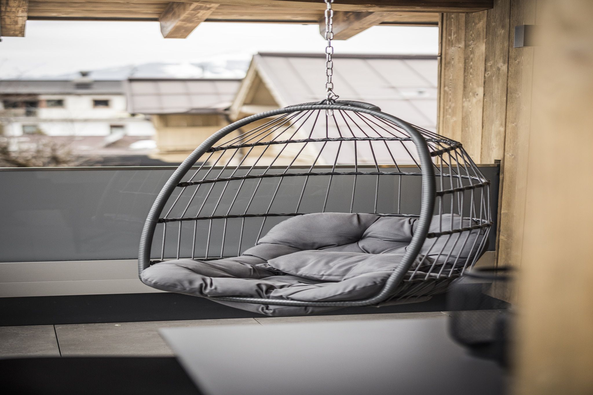 A hanging chair with cushions in a modern interior setting.