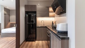 A modern kitchen with a built-in refrigerator, a sink, and a toaster. - Luxe Paradise Suites To Ngoc Van (Hanoi)