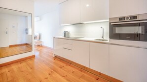 A modern kitchen with white cabinets, a stainless steel sink, and a Bosch oven. - GuestReady - Night out adventure in Lisbon (Lisbon)