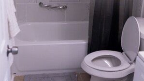 Ein Badezimmer mit Badewanne, Toilette und Handtuchhalter.