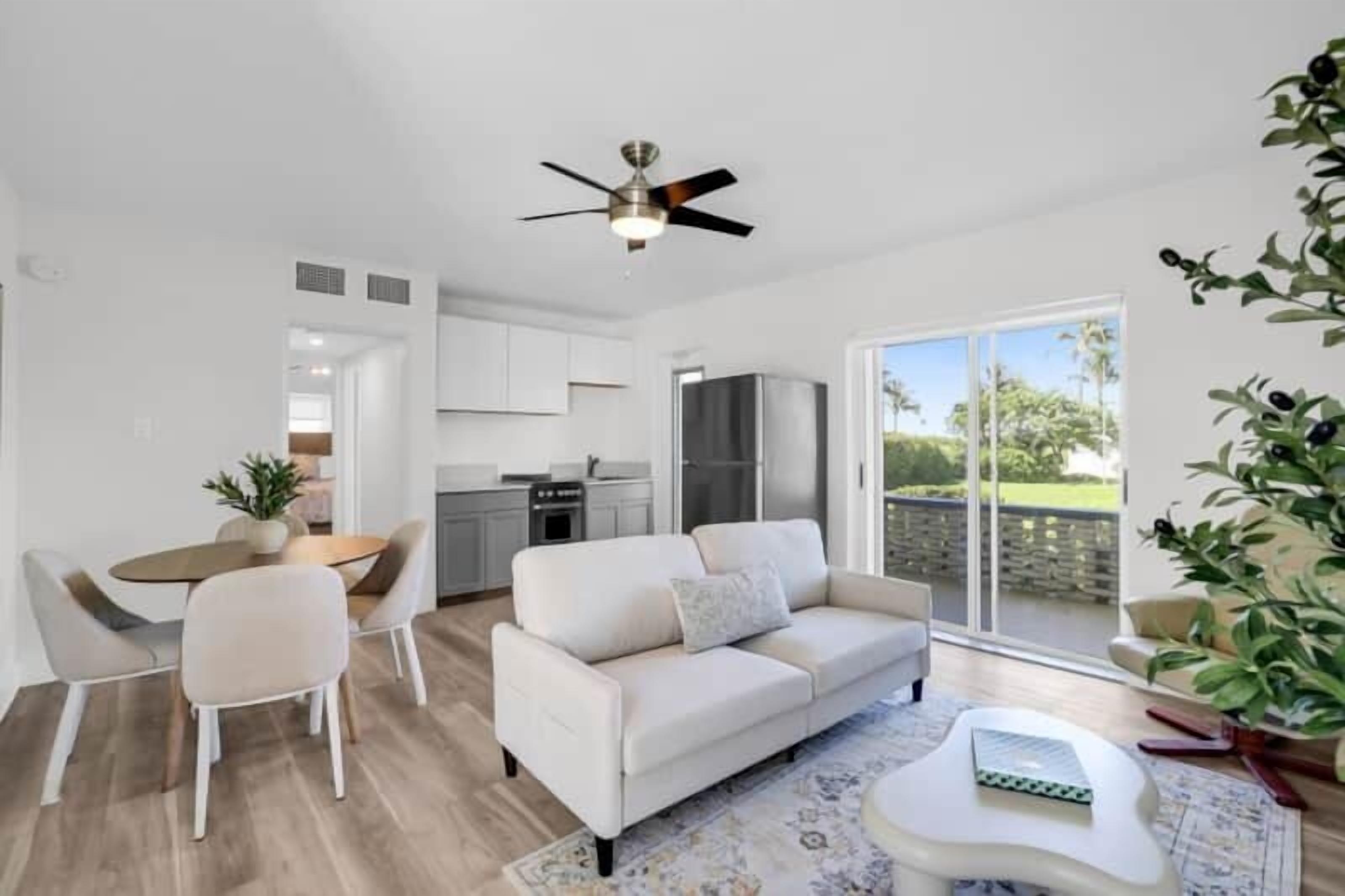 A modern living room with a sofa, coffee table, and dining area.