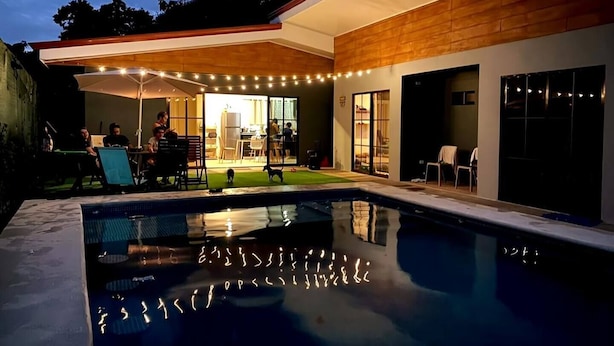 A modern house with a swimming pool, outdoor seating, and string lights. - Villa Perezosa (sloth) (La Fortuna)