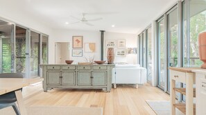 Una cocina moderna con una isla central, un sofá blanco y un comedor.