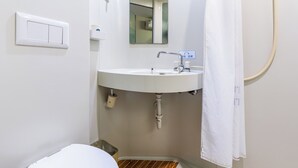 Un bagno con lavandino bianco, specchio e tenda per la doccia.