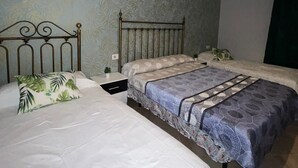 A bedroom with two single beds, a nightstand, a small table with a plant, and a hanging red light fixture. - CT 355 AL - Faro's Pechina Rural (Pechina)